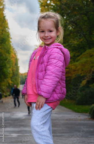 portrait pretty beautiful smiling preschool girl pink clothes posing park alley 