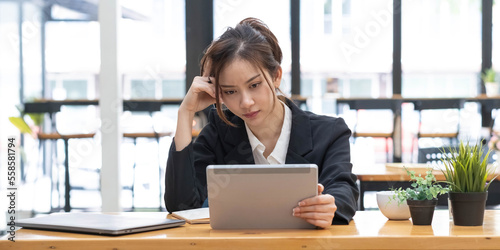 Sad Young woman employee having problems about her debts and financials. Frustrated Asian Beautiful businesswoman feeling depression, exhausted, tired, lazy during working at the office.