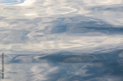Beautiful abstract watercolor natural background of rippled water surface with distorted shapes, fluffy clouds and blue sky reflections. Copy space for​ graphic​ design of posters or banners