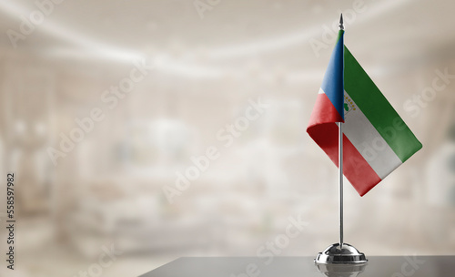 A small Equatorial Guinea flag on an abstract blurry background photo