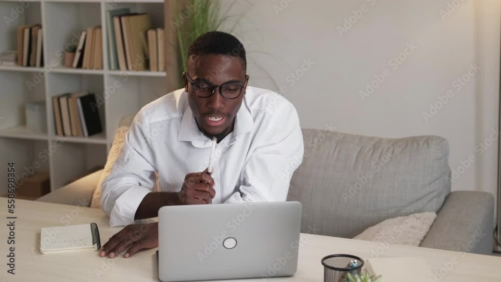 Web meeting. Online webinar. Digital conference. Serious man explaining business strategy on laptop video call at home desk. Web meeting. Online webinar. Digital conference. Serious man explaining business strategy on laptop video call at home desk.