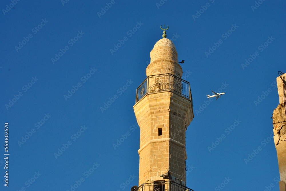 Minaret of a mosque on the sunset over blue sky