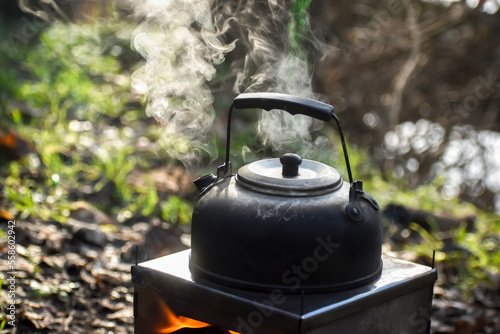 Kettle boils on a tourist firewood stove, outdoor recreation