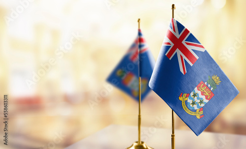 Obraz na płótnie Small flags of the Cayman Islands on an abstract blurry background