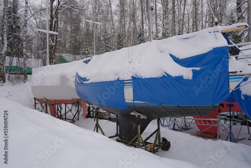 Yacht, boat, ship on the shore under a canopy awning in the snow