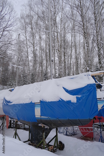 Yacht, boat, ship on the shore under a canopy awning in the snow