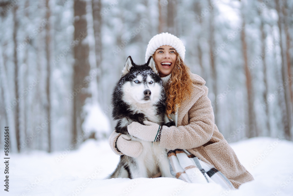 Happy woman walking her dog in the winter and both explore the snow together in playful mood. Friendship, pet and human. Happy woman walking her dog in the winter and both explore the snow together in playful mood. Friendship, pet and human.