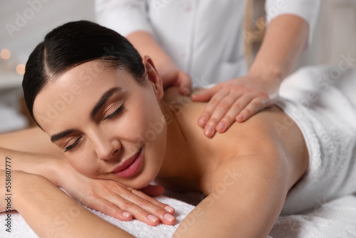 Beautiful woman receiving back massage in beauty salon, closeup