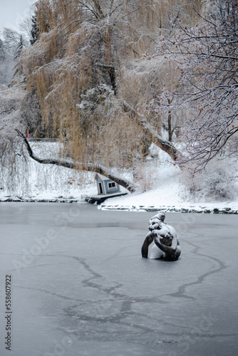 Sculpture of a woman covered in snow in the middle of the pond in Stryiskyi park in Lviv  photo