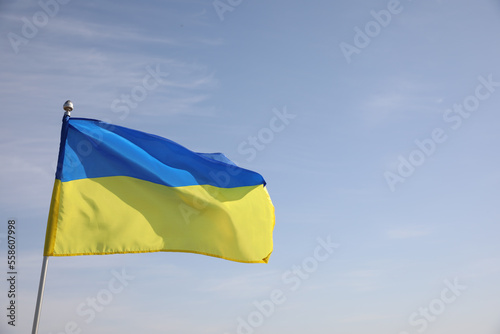 National flag of Ukraine against blue sky. Space for text