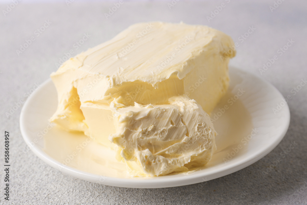 Plate with tasty homemade butter on white textured table Plate with tasty homemade butter on white textured table