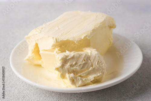 Plate with tasty homemade butter on white textured table