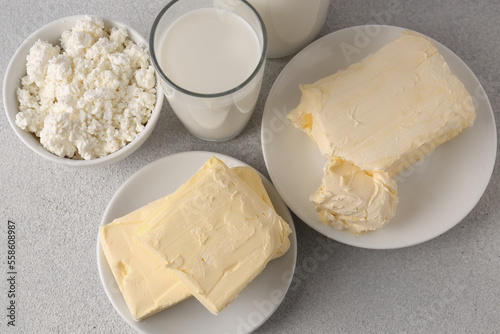 Tasty homemade butter and dairy products on white textured table, flat lay