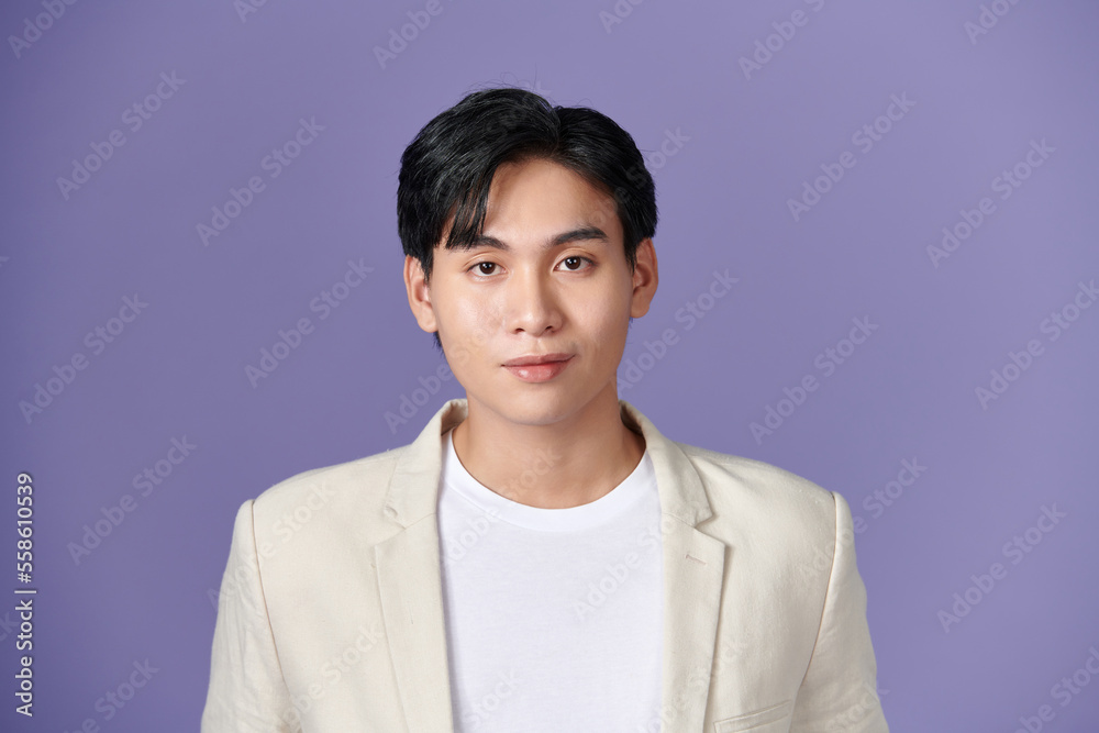 Smiling young Asian businessman in beige suit isolated on purple background Smiling young Asian businessman in beige suit isolated on purple background