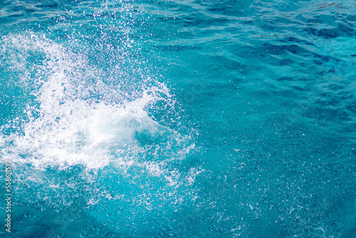 Splashes of blue, sea water with foam bubbles. A splash of nature on a summer day. blue sea background with splashing water. sea vacation concept. © AndErsoN
