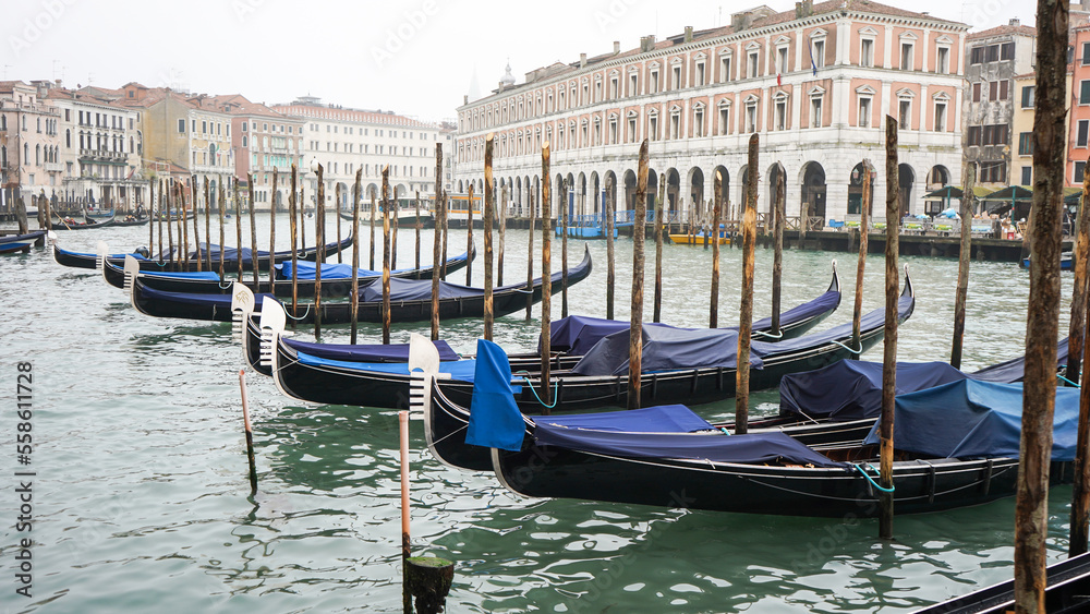 Foggy Venice in Winter, empty gondolas stopped at the city center dock 