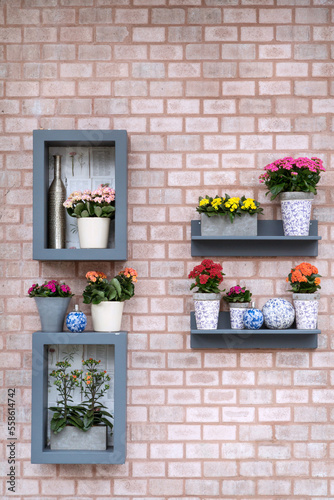 Beautiful flowers shelf on brick wall background