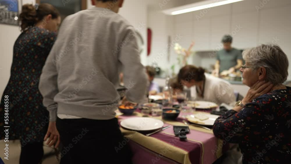 Family at dinner table. Lifestyle candid shot of people gathered together for holiday meal Family at dinner table. Lifestyle candid shot of people gathered together for holiday meal