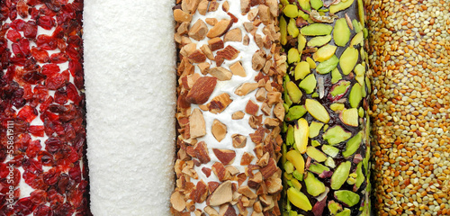 Traditional turkish delight with dry barberry, coconut flakes, almond, pistachio and sesame, top view background   