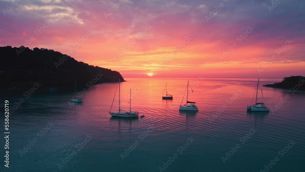 Aerial view of beautiful sunset over the tropical sea with sightseeing yacht cruise in summer Aerial view of beautiful sunset over the tropical sea with sightseeing yacht cruise in summer