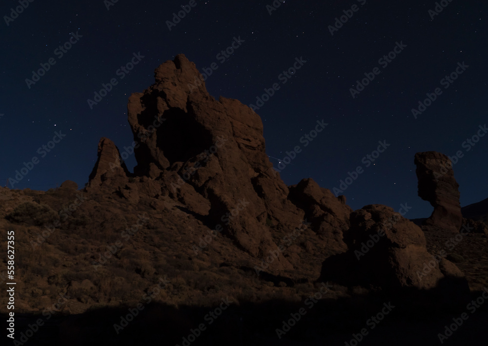 Long exposure night shot of Roques de Garcia with Roque Cinchado volcanic rock formation at El Teide national park, night winter sky with stars on dark blue. Tenerife Canary islands, Spain