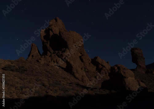 Long exposure night shot of Roques de Garcia with Roque Cinchado volcanic rock formation at El Teide national park, night winter sky with stars on dark blue. Tenerife Canary islands, Spain