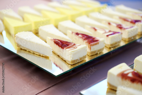 Pieces of cheesecakes on a mirrored tray on the buffet table