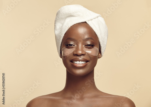 Foto Face of black girl in hair towel with eye patches on skin.