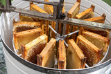 Apiculture - A la miellerie - Cadres remplis de miel rangés dans un extracteur à manivelle