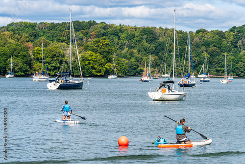 People on Paddle Boards and Yachts on River Dart over Dittisham and Greenway Quay, Devon, England