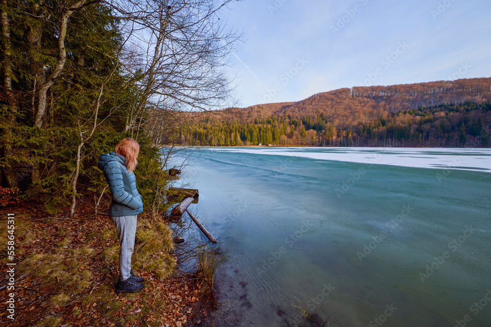 © czamfir - a woman sitting and looking towards a lake © czamfir - a woman sitting and looking towards a lake