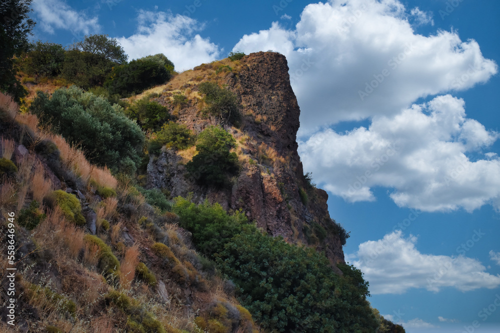 Fototapeta premium Cloud clusters and sky view from the top of a mountain with various dwarf Mediterranean scrub plants