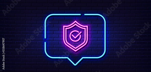Neon light speech bubble. Approved shield line icon. Accepted or confirmed sign. Protection symbol. Neon light background. Approved shield glow line. Brick wall banner. Vector