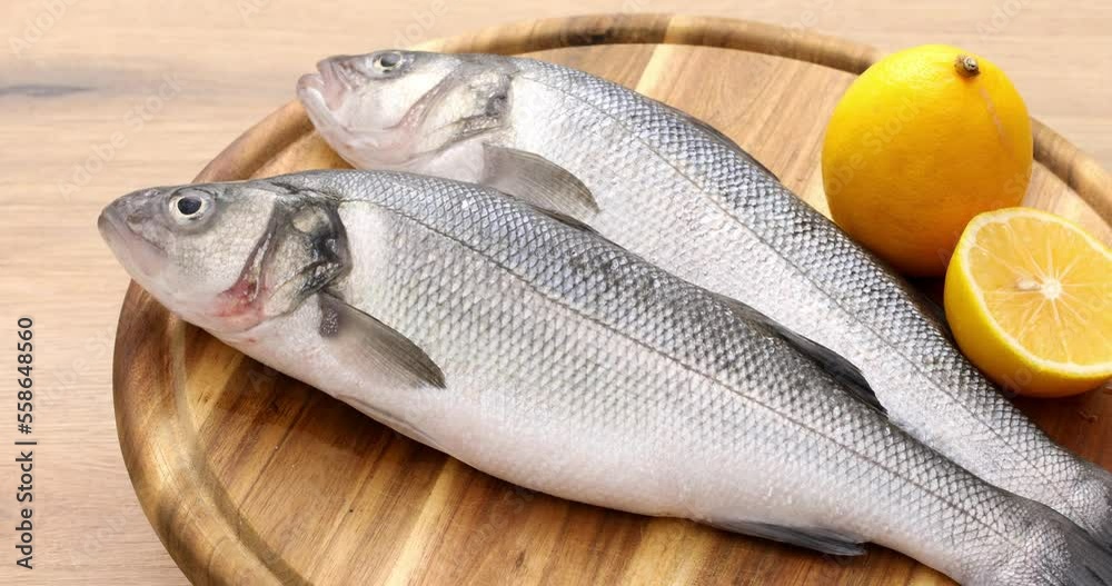 Raw fish with lemon lies on a wooden cutting board