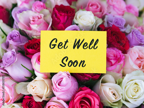 Canvas Print A yellow greeting card with words Get Well Soon laying on a bouquet of colorful