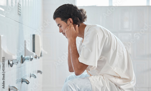 Islam, ablution and man washing before prayer in bathroom at mosque in Iran, spiritual cleaning ritual. Islamic culture, water and worship, muslim guy in cleansing care routine to prepare for praying