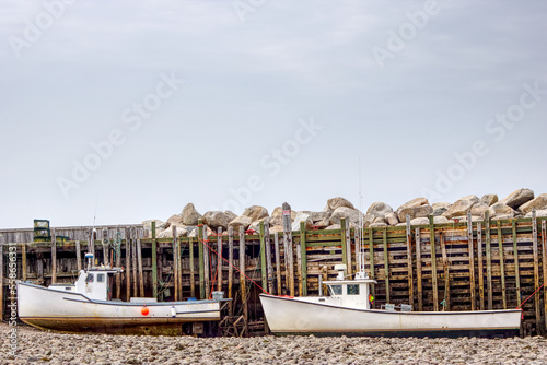 two fishing boats sitting on the bottom at low tide in the bay of fundy