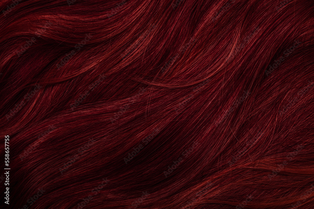 Naklejka premium Dark red hair close-up as a background. Women's long brown hair. Beautifully styled wavy shiny curls. Coloring hair with bright shades. Hairdressing procedures, extension.
