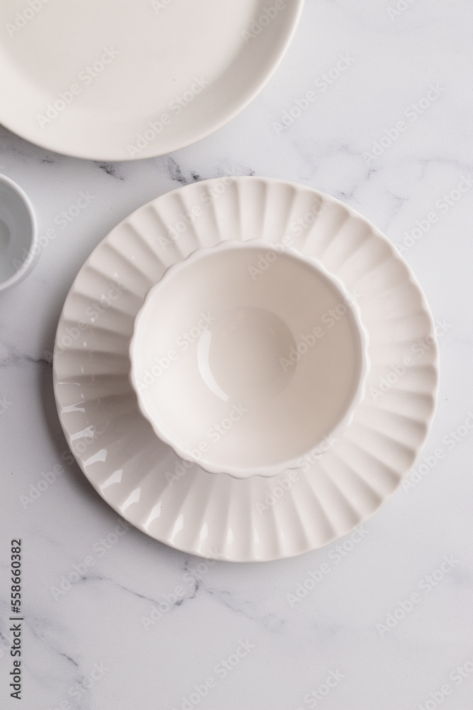 Empty tableware - white plate, a bowl and a cup on white table as a background for a dish foodbackground
