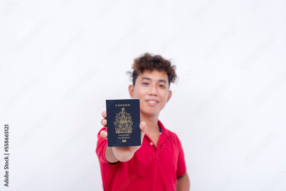 A happy asian guy shows his newly acquired US passport. A naturalized american citizen. Isolated on a white background. A happy asian guy shows his newly acquired US passport. A naturalized american citizen. Isolated on a white background.