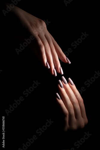 Manicured nails - Woman hands on black background 