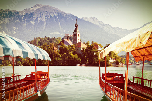 Typical wooden boats, in slovenian call Pletna, in the Lake Bled, the most famous lake in Slovenia with the island of the church (Europe - Slovenia) - toned image