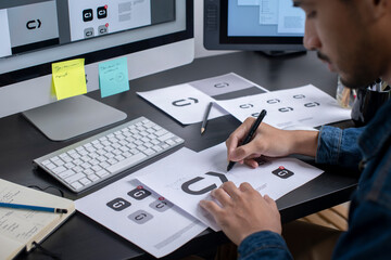 Graphic designer drawing sketches logo design. The concept of a new brand. Professional creative occupation with idea.