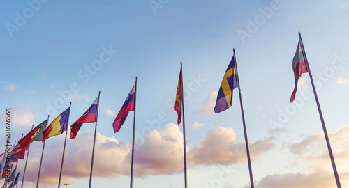 National flags in a row  against sunset blue sky with clouds	