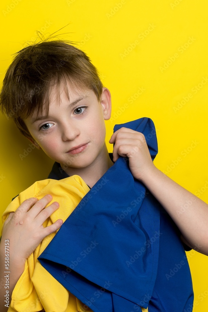 a boy of European appearance holds the flag of ukraine in his hands a boy of European appearance holds the flag of ukraine in his hands