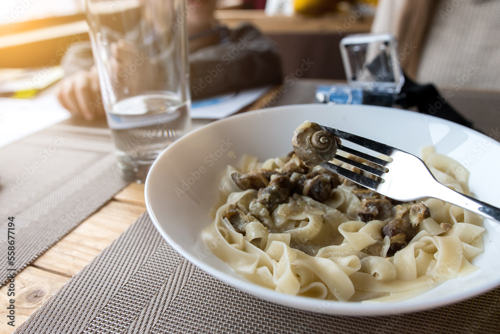 pasta with snails in a white plate. dietary dishes
