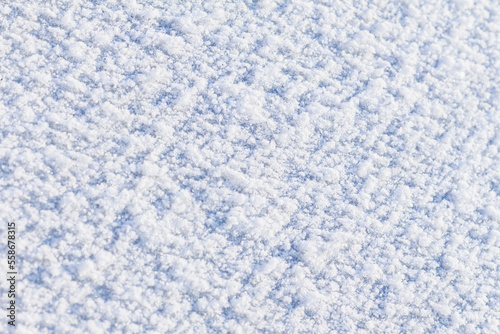 Background of fresh snow texture in blue tone, selective focus, copy space. Fractional snow texture