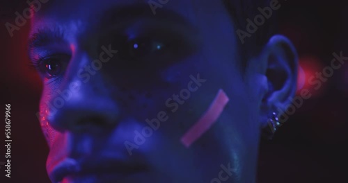 Close up of a young man in makeup in blue lights photo