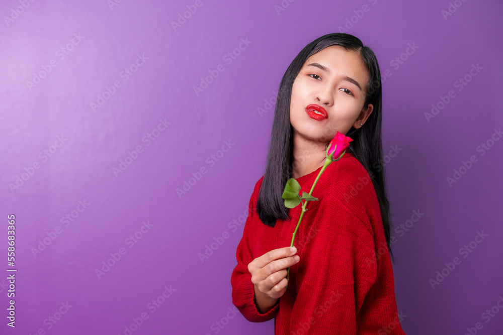 Profile portrait of asia beautiful young woman smelling and holding rose flowers isolated on violet color background for valentine day color tone