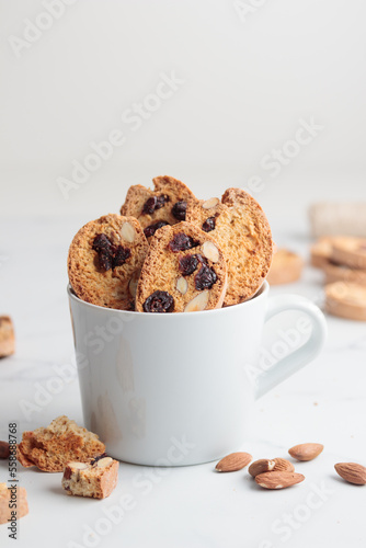 Biscotti in a white cup cantucci cookies with almond and cranberry on white background